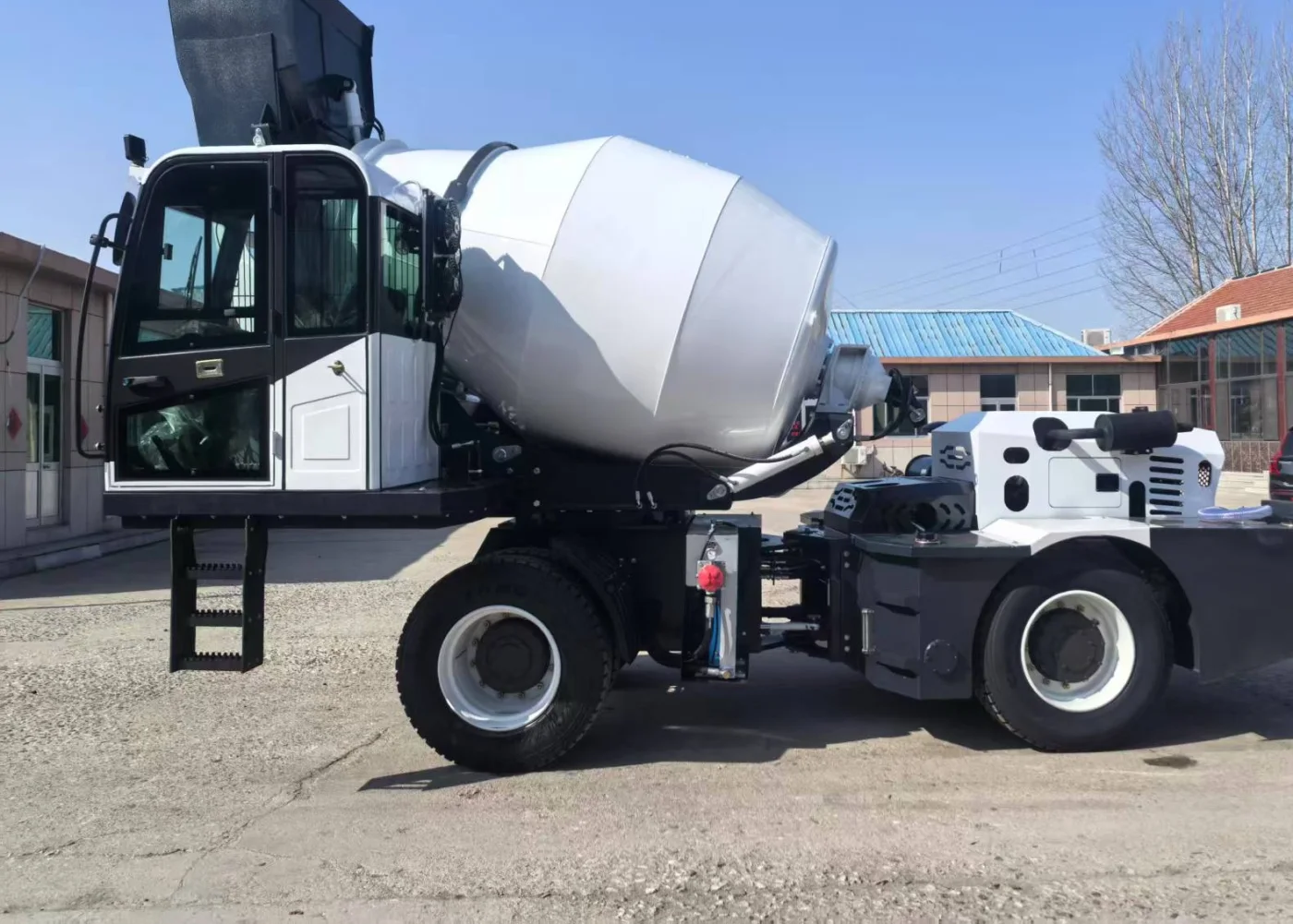 Self-loading concrete mixer, side view, drum raised on the carrier frame