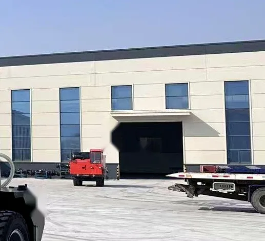 Plant loading bay with a roller shutter door, a small red truck and a flatbed trailer backed onto the hardstanding